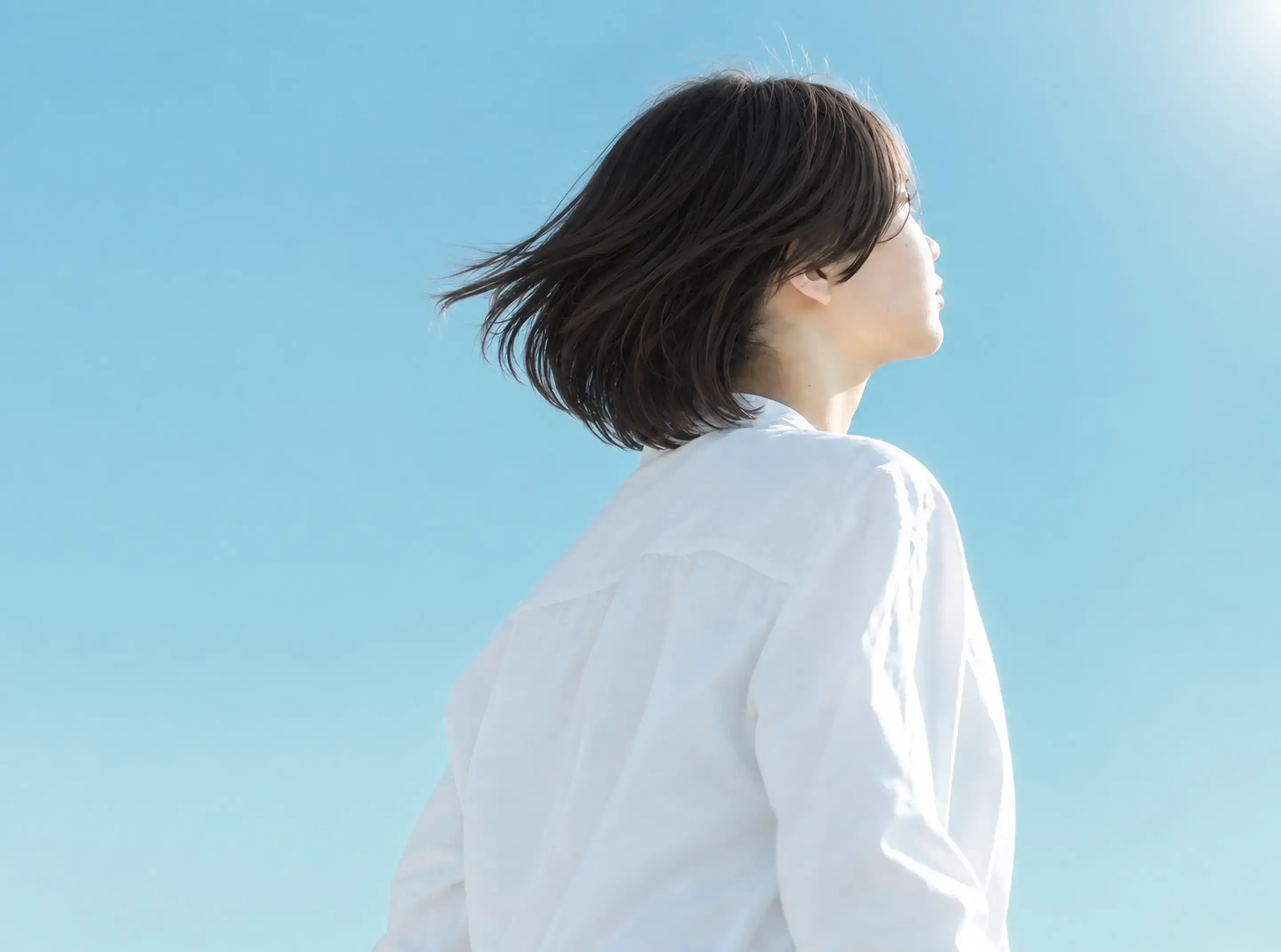 光の差す方向を見つめる女性